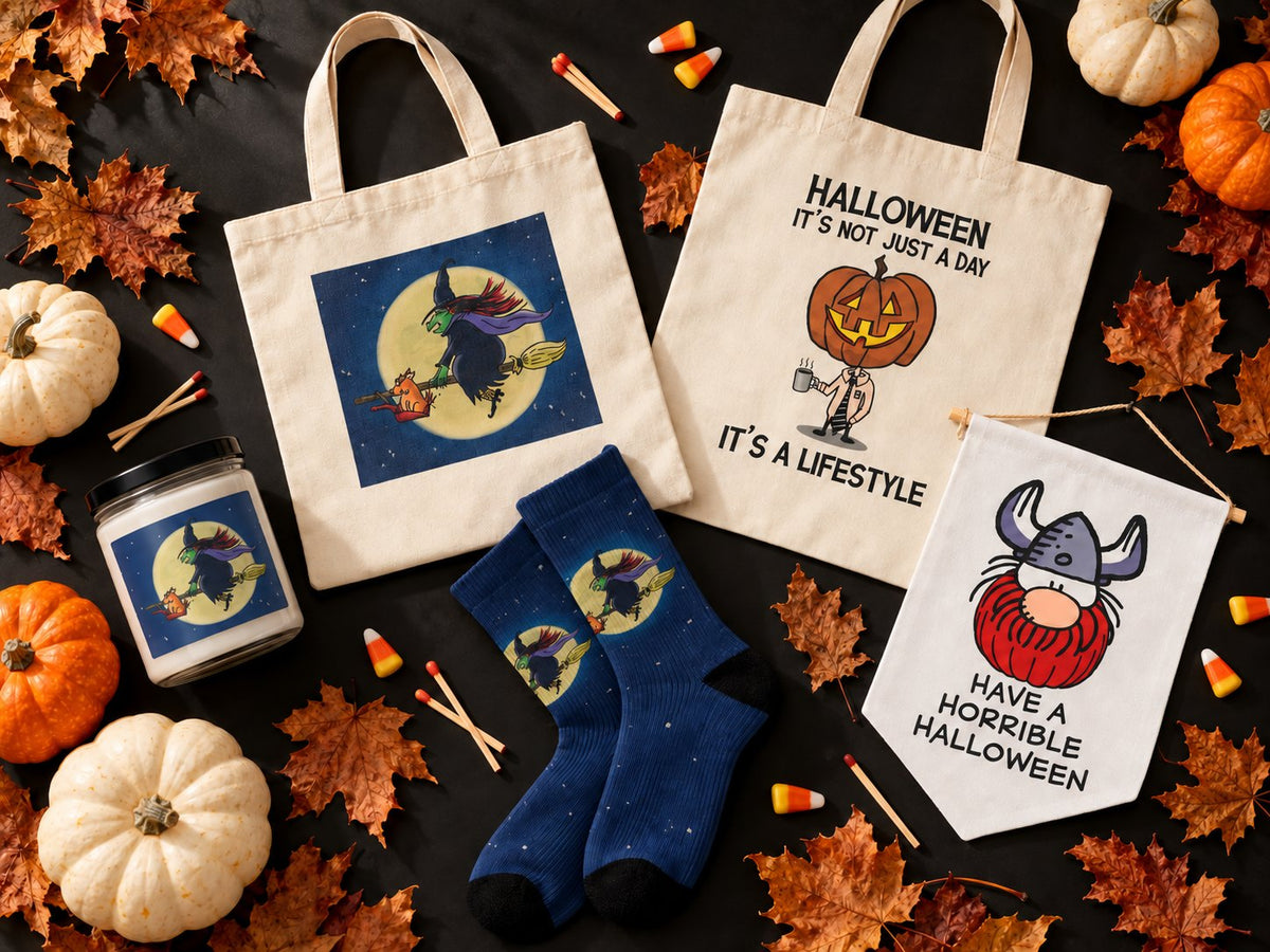 Halloween candles, totes, socks and a pennant from Six Chix, Never Been Deader and Hagar the Horrible, laid out with pumpkins and leaves.